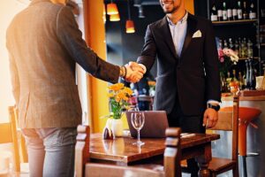 Men in suits shaking hands in a cafe